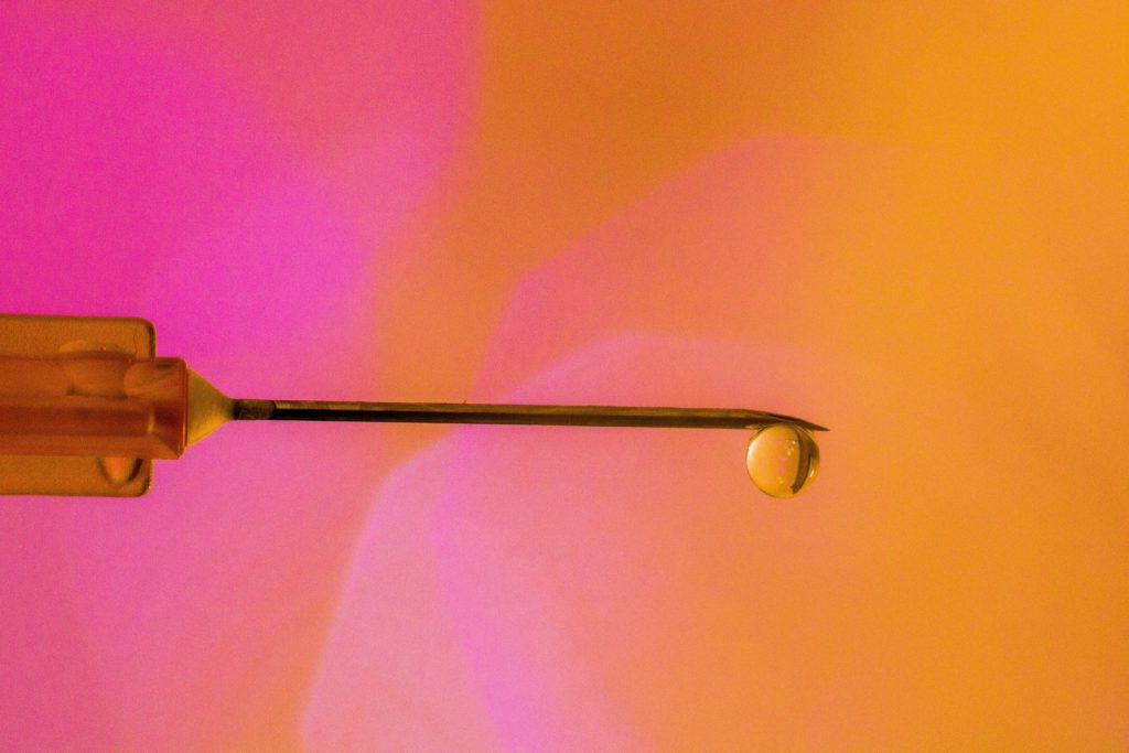 needle with a pink-orange background